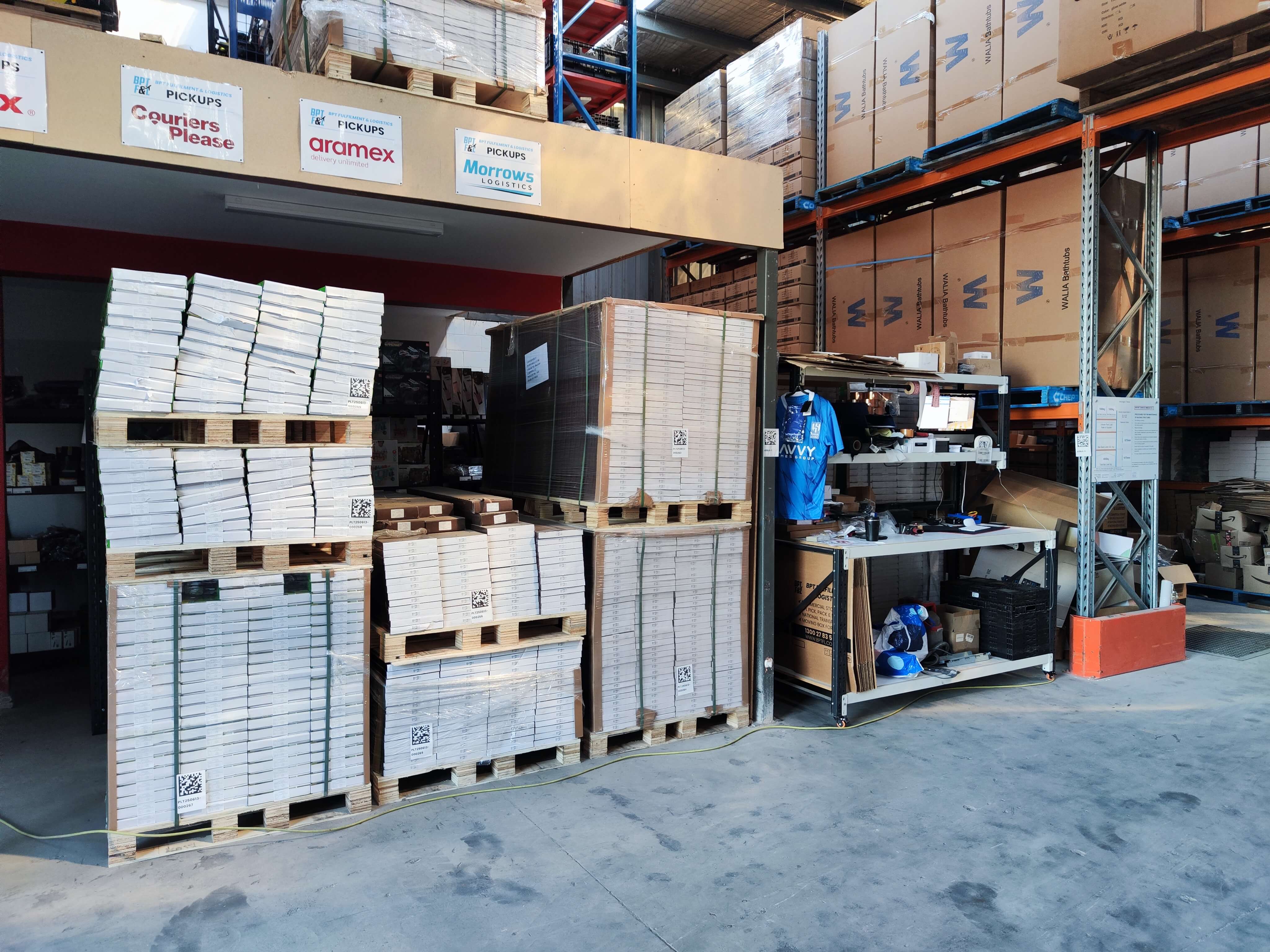 Pallets stacked below mezzanine at MEL1 next to workbench